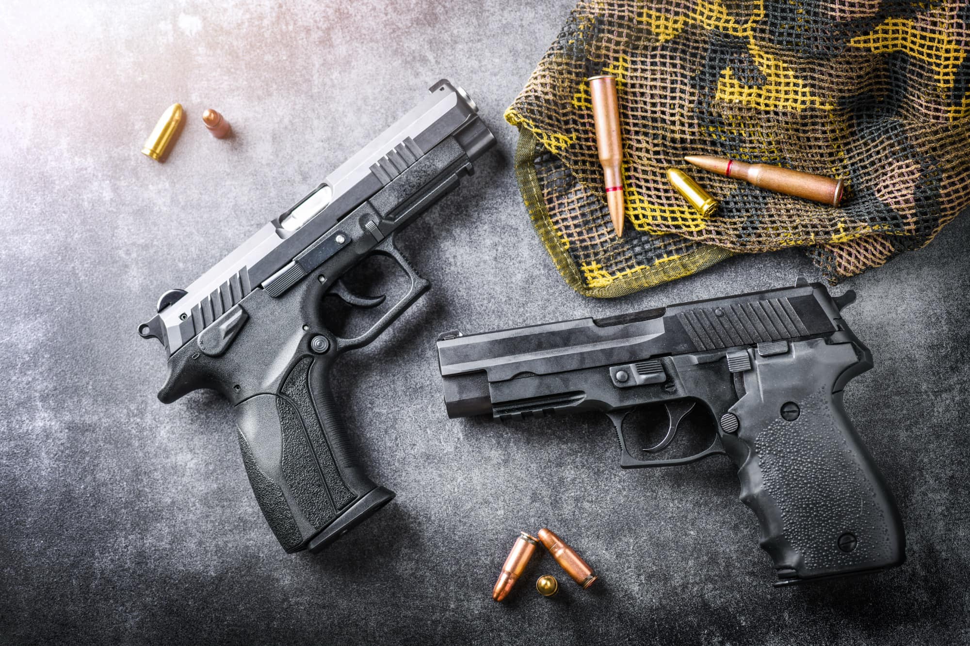 handgun on dark stone table ammunition